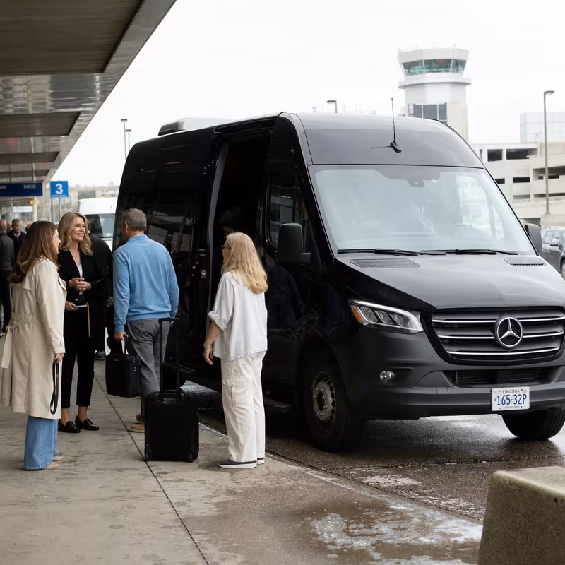 Group boarding a white charter bus for Airport Transportation transportation in Des Moines