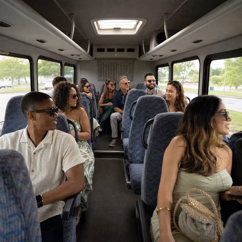 Group boarding a white charter bus for Private Event Transportation transportation in Des Moines