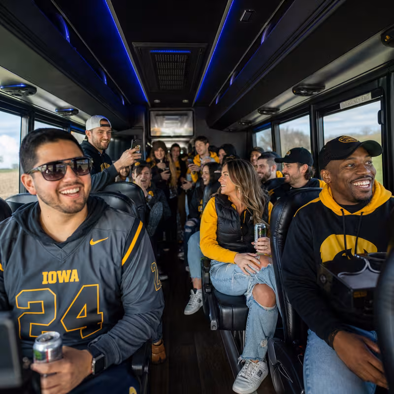 Group boarding a white charter bus for Sporting Event Transportation transportation in Des Moines
