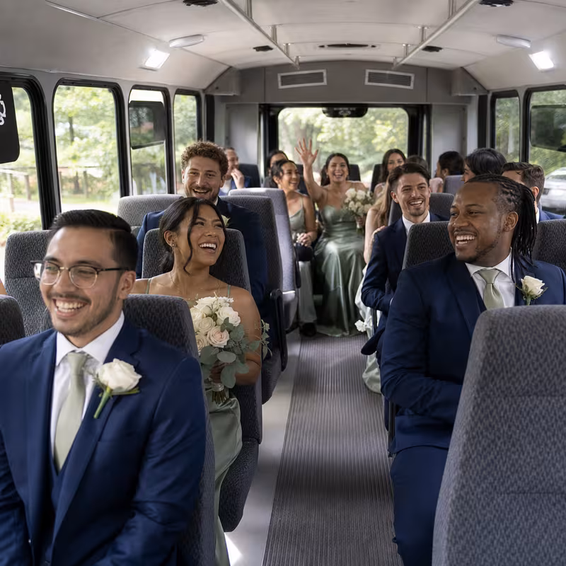 Group boarding a white charter bus for Wedding Transportation transportation in Des Moines