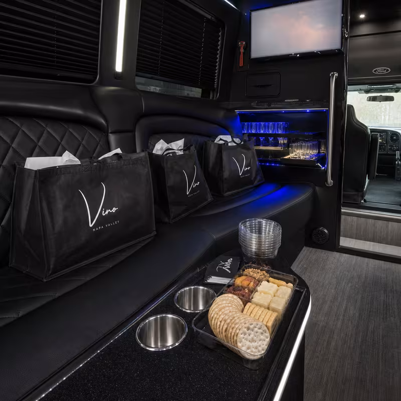Party bus interior with wraparound leather seating and LED lighting in Des Moines